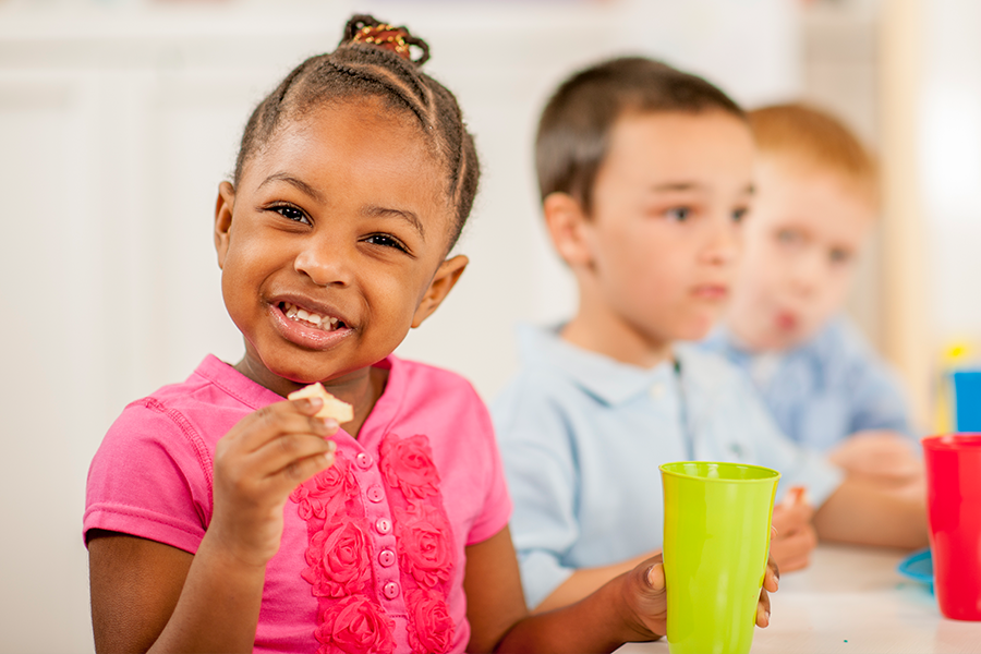 des enfants qui sont assis et qui mangent une collation